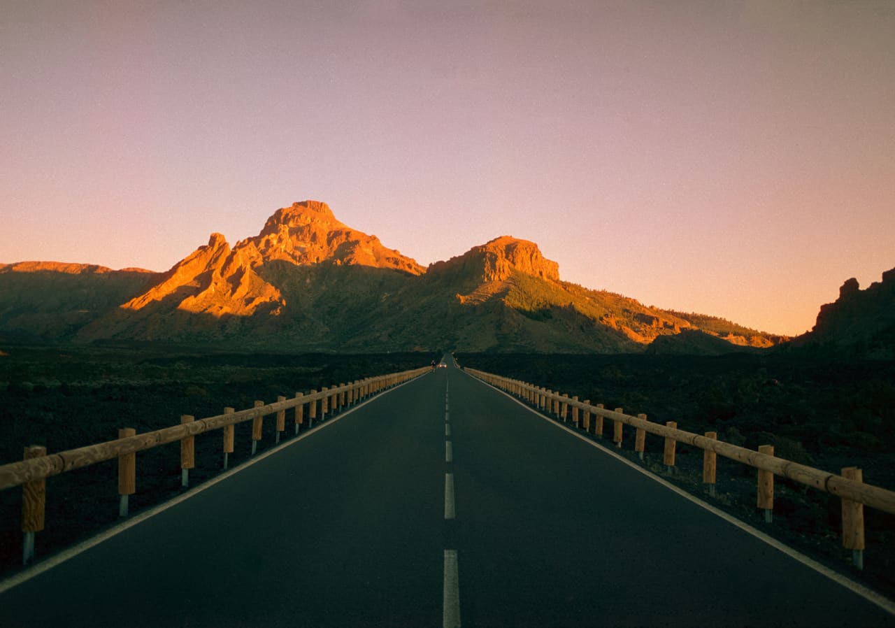 An open road through a sunset landscape